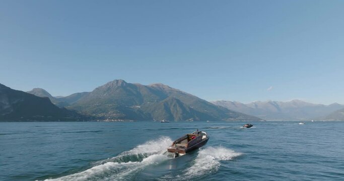 4K Aerial - Following close behind a classic boat in Lake Como, Italy
