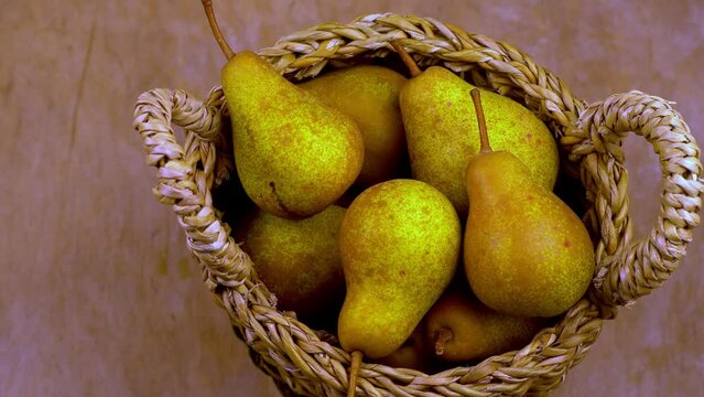 Pears in basket on a wooden background. Fruit harvest. Autumn still life. Pear variety Bera Conference. Vitamin food.
