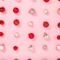 Background with pink and red decorative balls on a pink background. Top view, flat lay.