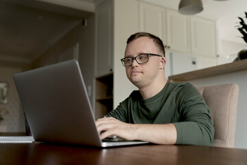 Man with down syndrome using laptop at home