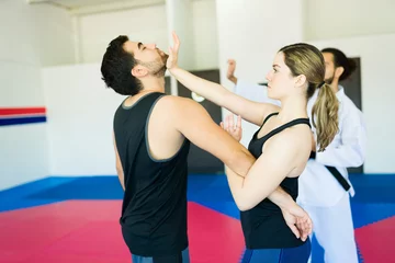 Fotobehang Woman defending from an attacker during a self-defense class © AntonioDiaz