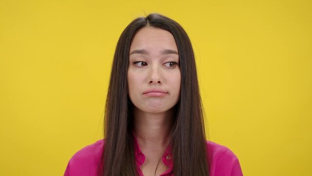Confused woman shrugs and purses lips looking thoughtful