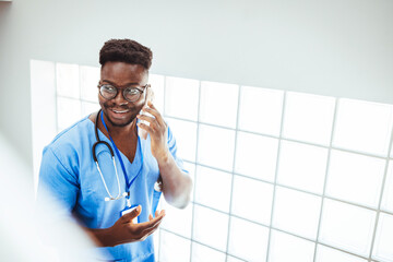Portrait Of Male Nurse Wearing Scrubs In Exam Room. Portrait of male nurse with some medical record...