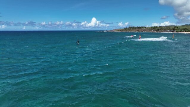 Wing foilers and windsurfers sail upwind into open ocean, Hookipa Beach Hawaii
