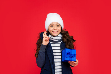 happy child in puffer jacket and hat hold box. kid with present. teen girl