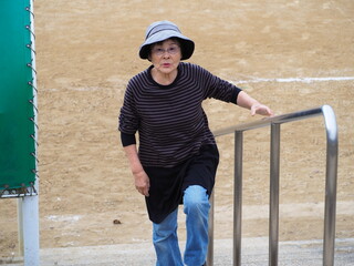 階段を登る高齢日本人女性