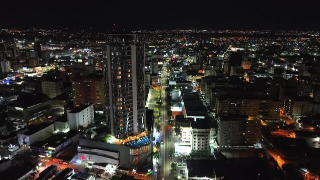 Drone Flyby Impressive Building Of Embassy Suites Hotel At Night In The District Of Naco, Santo Domingo, Dominican Republic. aerial