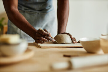 Fototapeta na wymiar Close up of male artist creating handmade ceramic bowl in cozy pottery studio, copy space