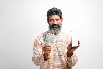 Young indian farmer showing smartphone and money on white background.