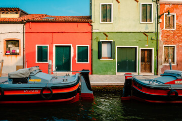 Fototapeta na wymiar Burano dwellings in front of canal with moored boats