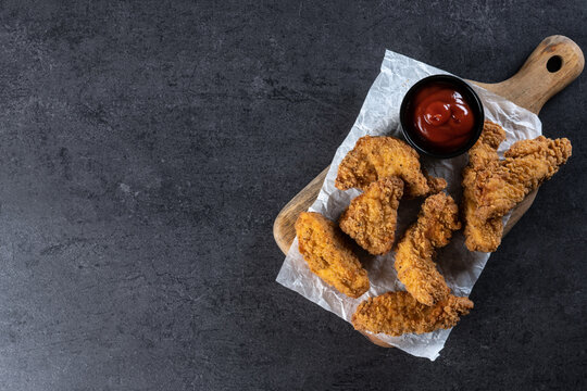 Crispy Kentucky fried chicken on black slate background. Copy space