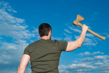 back view of man with axe. man hold ax. brutal man on sky background