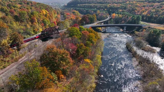 Lehigh Gorge Scenic Rail train passes over bridge. Fall autumn foliage is in peak color. Aerial of top tourist attraction in Jim Thorpe Pennsylvania.