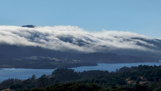 Waves of cloud flowing over the peaks of Crystal Springs Reservoir in San Mateo County, California  near I-280