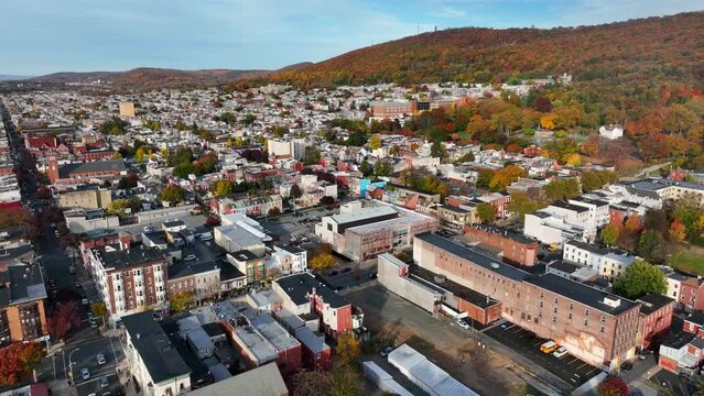 American city with mountain in distance. Aerial establishing shot of autumn fall foliage in USA.