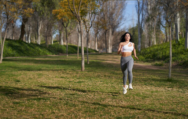an athletic woman running in a park with her hair down as seen from the front