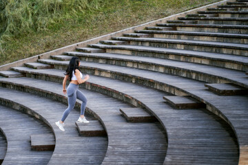 a young female athlete runs up a flight of wooden stairs with steps