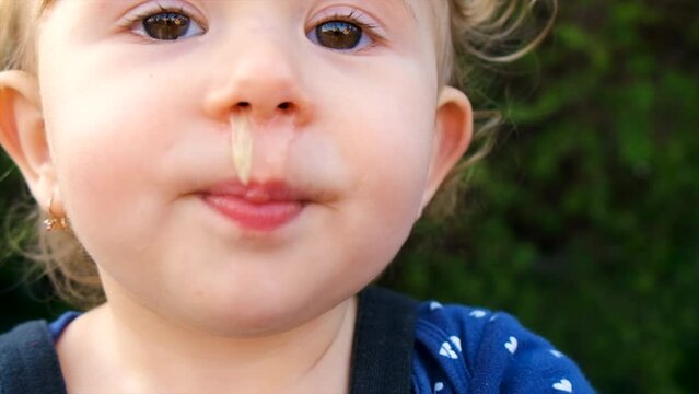 The child has snot on his face. Selective focus.