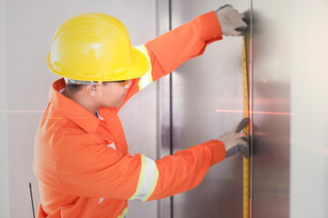Worker Engineer uses a meter tape to measure values according to the laser level
