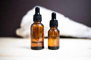 Glass dropper bottles on an abstract background. Side view, place for text.