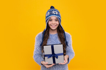 Child with gift present box on isolated background. Presents for birthday, Valentines day, New Year or Christmas. Happy face, positive and smiling emotions of teenager girl.