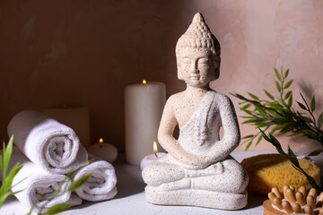 Spa beauty wellness concept with statue of Buddha with burning candles for spa time.