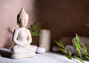Beauty wellness concept with statue of Buddha  and with burning candles for spa time.  Religion concept.