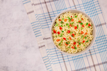 Instant noodles in bowl on gray background