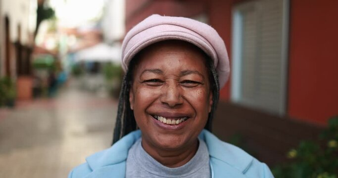 Senior african woman smiling on camera outdoor during winter time