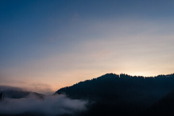 A panoramic view from above of the mountain peaks in thick clouds.