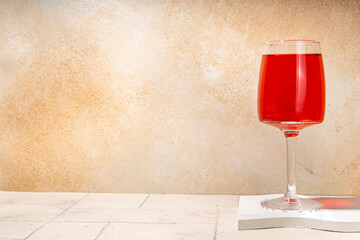 Wineglasses of red and white wine on beige tiled background 