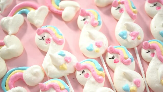 Step by step. Holding close to the camera, the unicorn meringue pops cookies.