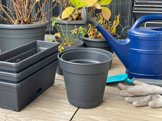 Empty flower pots and hydrangea plants in autumn time on a balcony, preparing the balcony garden for winter