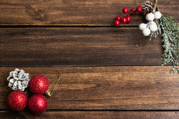 Christmas Holiday evergreen branches and red berries  over wood background with copy space