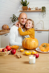 Portrait dad and daughter. Тhey together cut pumpkin for holiday Halloween or Thanksgiving day.