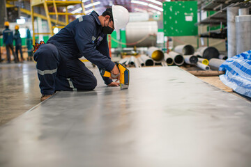 Male worker inspecting surface on plate stainless