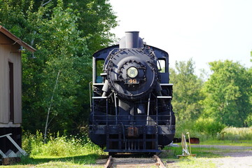 A vintage old 1800s steam train engine sits at the train museum on display.