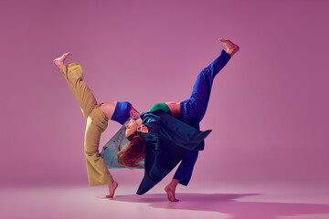 Contemporary dance couple in motion and action isoltaed on crystal pink background. Young stylish...