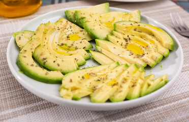 ripe avocado pulp cut into pieces sprinkled with lemon juice on a plate