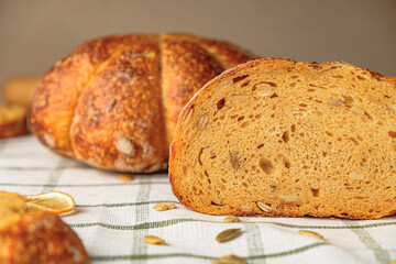 Slices of craft pumpkin bread  with pumpkin seeds . Homemade wholemeal rye yeast-free bread on a white striped towel