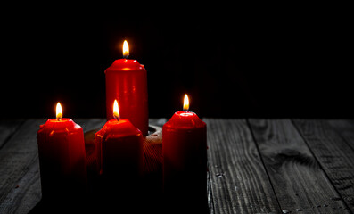 Burning candles on isolated dark room background