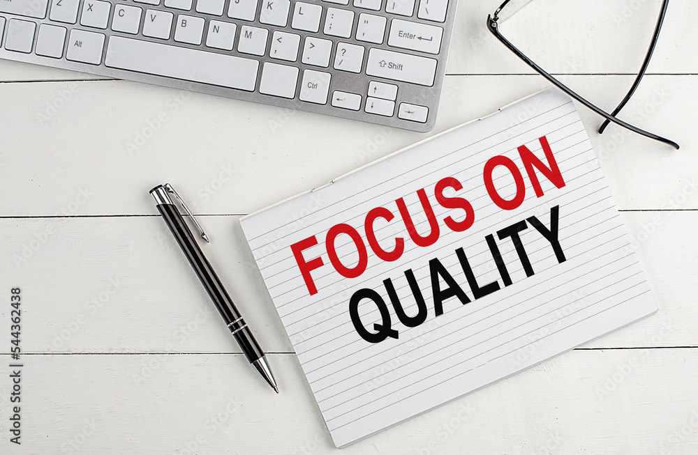 Poster text focus on quality on a keyboard on white background