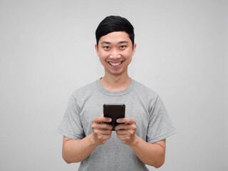 Positive asian man grey shirt hold mobile phone happy smile isolate