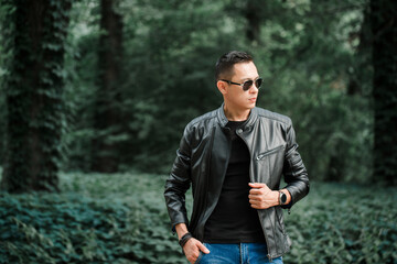 Portrait of a handsome brutal man in a black leather jacket