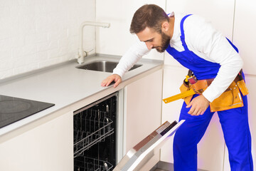 Crafts man repairs broken dishwasher