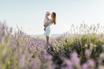 happy mom holds her daughter in her arms, smiles and rejoices