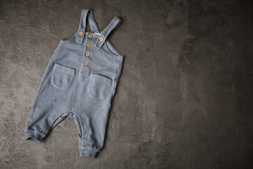 jumpsuit with suspenders for a baby on a gray background
