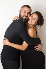 Pregnant couple having fun laughing and hugging