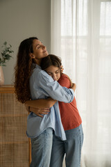 Young loving mother hugging her teenage daughter, mom demonstrating unconditional love for child,...