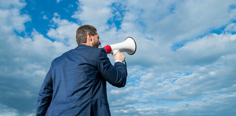back view of businessman warning in loudspeaker on sky background